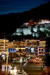 Potala Palace at night with illuminated streets and bustling traffic, Lhasa, Tibet