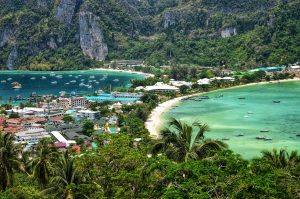 Aerial view of Phi Phi Island in Thailand with turquoise water, white sandy beach, boats and limestone cliffs