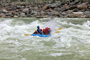 Group of people white-water rafting through rapids on the Trishuli River in Nepal.