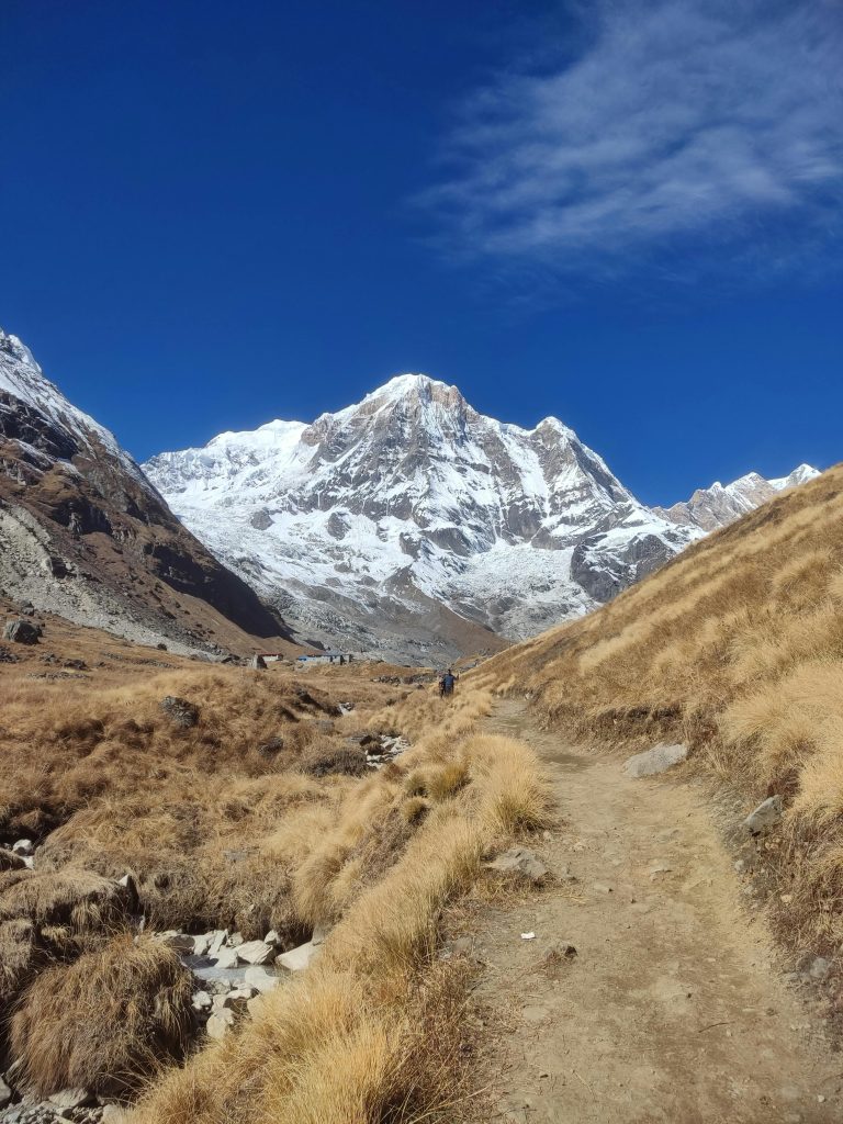 Dirt trail heading toward snowy peak of Annapurna South mountain, Nepal