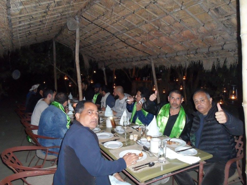 Diverse international guests dining at an eco-friendly community lodge in Nepal with EHT Travel.