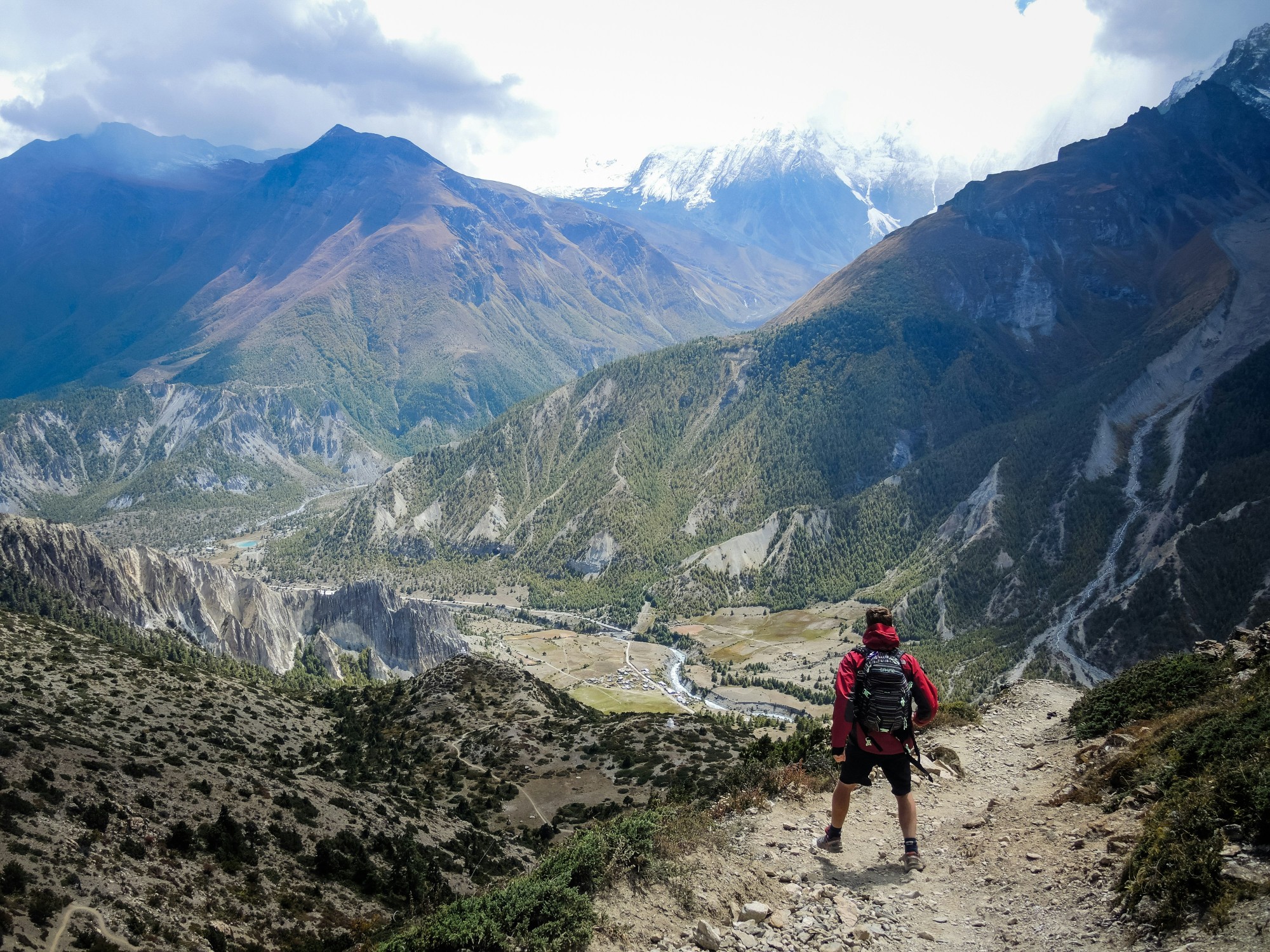 A hiker overlooks the dramatic Manang valley landscape during the Annapurna Circuit trek in the Nepal Himalayas.