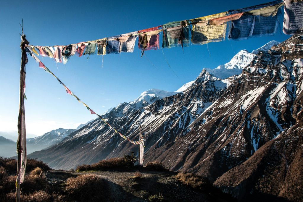 Prayer flags hanging in front of snow-capped Annapurna mountain range in Nepal.