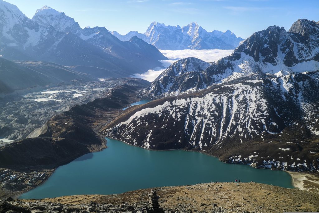 High-altitude turquoise Gokyo Lakes nestled in the Gokyo Valley, viewed from the Gokyo Ri summit with snow-capped Himalayan peaks in the background.