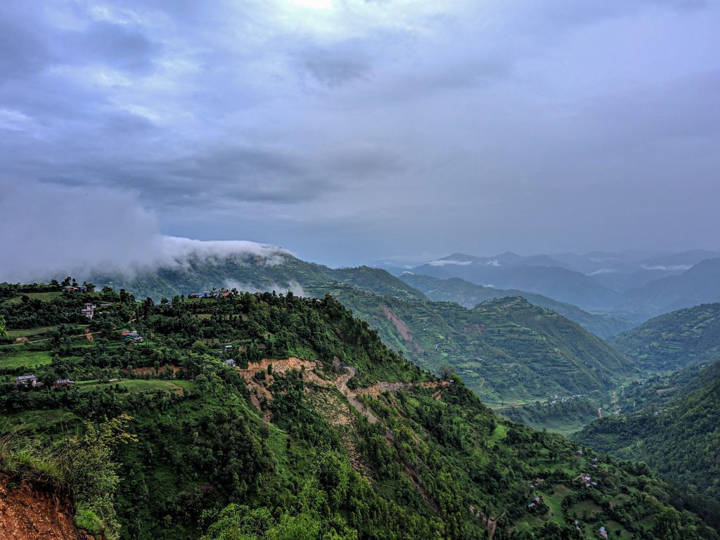 Panoramic view of lush green hills and dramatic cloud formations over the Kathmandu Valley, Nepal.