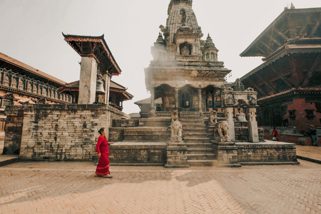 Shikhara-style stone Vatsala Durga Temple with elephant statues and the large bronze Taleju Bell in Bhaktapur Durbar Square, Nepal.