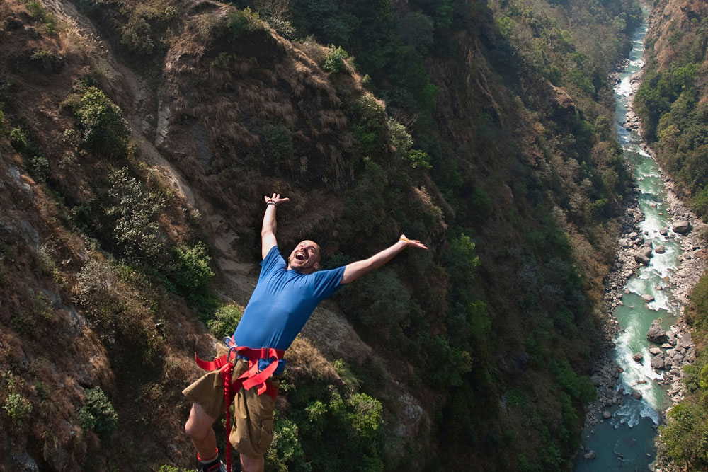 The Ultimate Guide To Adventure In Nepal: Traveler enjoying the bunjee jump in Nayapul, Nepal